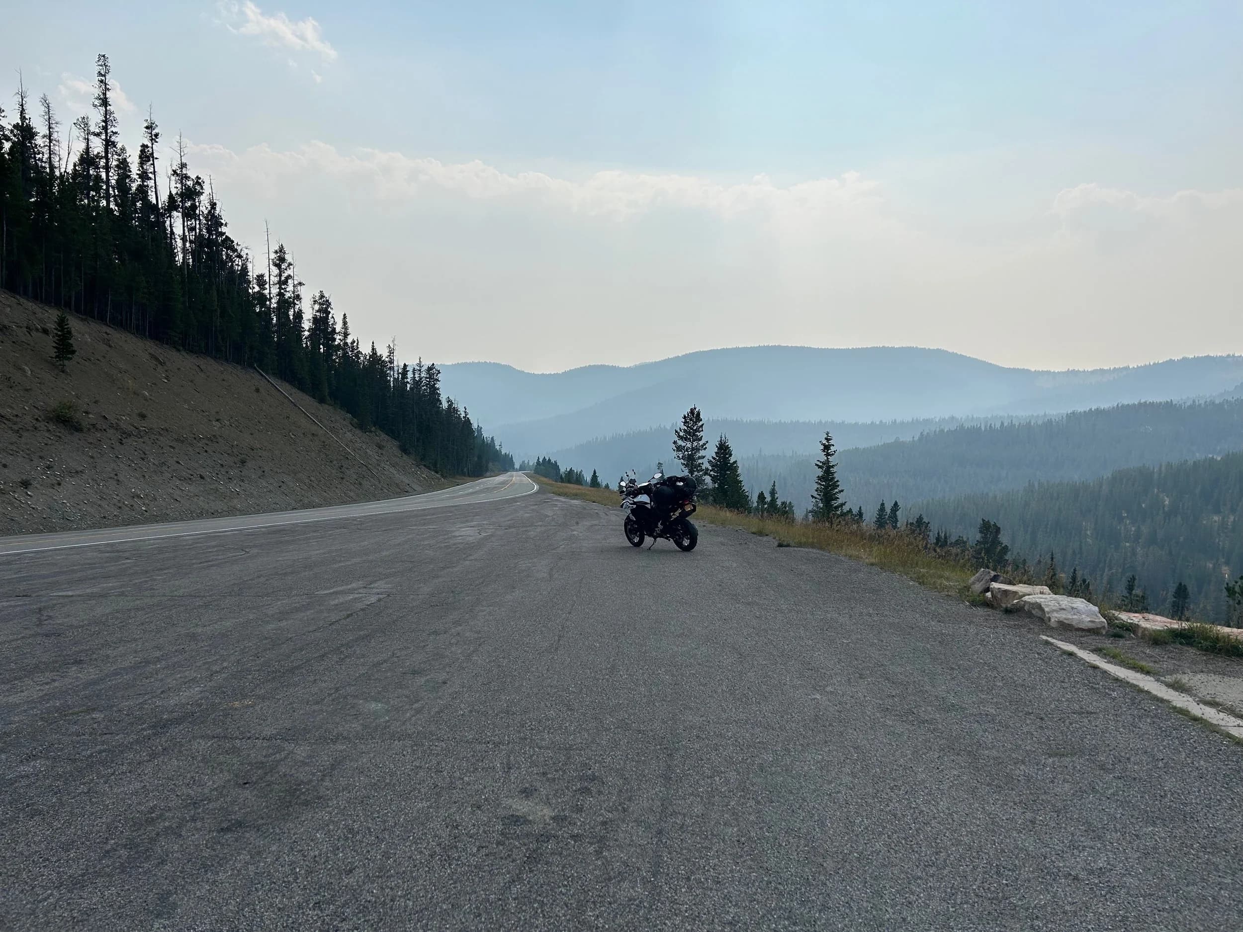 Trip Report: NW National Parks Loop
I left my job recently to take a much needed sabbatical and figure out what I’m doing next. A few weeks after my last day at work I embarked on what was to be a three week tour of NW-ish National Parks from Portland, to include Olympic, North Cascades, Glacier, Yellowstone, Grand Teton, Craters of the Moon, Lassen Volcanic, and Crater Lake.
I ended up missing Grand Tetons due to weather and I had to cut the trip short before I got to Lassen (family medical issue), so Lassen and Crater Lake remain unvisited.
Trip Dates: Sept 3 - Sept 16 (13 days)
Total Travel Miles: 3478 (does not include local miles for store runs, etc.)
Total Gallons of Gas Used: 82
Equipment: 2021 Benelli TRK502X Gaia GPS & Google Maps running on Sonim XP8 rugged Android phoneButler Motorcycle Maps (paper maps of best M/C roads in the country) iPhone 14 (main camera) Akaso Brave 7 helmet-mounted adventure camera Spot X satellite communicator and tracker Wolfman Luggage WP waterproof tank bag and saddle bags (no longer available) Watershed Colorado dry bag duffel (across the pillion seat) Kriega US-5 Drypack (tail bag) Kriega 3L hydration backpack (strapped to duffel, not worn)Marmot Ajax 2 tent Nemo hydrophobic down sleeping bag (non-mummy)Helinox ultralight cot MSR WhisperLite International stove
(Purchased in 1991 for my first moto trip: Detroit, MI to San Diego and back on an XT250)Gossamer Gear Bare Boxer bear-proof food canisters (two - one in each saddle bag)
Day 1 - Olympic National Park Date: Tuesday 9/3/2024
Destination: South Beach Campground, Olympic National Park
Travel Time: 4h 24m
Miles: 213Notes:
Planned to head west to Astoria then north from there, but left later than expected so headed up I-5 to US 12. I’ve driven/ridden that stretch of I-5 hundreds of times (starting in 1993). It’s boring and I hate it.
South Beach CG is first-come-first-served. I didn’t have issue getting a site. There is a long, tight loop of sites along the coastline, but I chose one of the sites further back near the bathrooms due to wind concerns. The bathroom building provided a sort of wind shelter for my site.
I used the heated grips on this leg; it was pretty chilly along the coast in the Olympic Peninsula. I almost didn’t install them, thinking I was being paranoid about the cold. I ended up using them a lot.
Day 2 - Ferry to Seattle / Burien Date: Wednesday 9/4/2024
Destination: Friend’s house in Burien, WA
Travel Time: 7h 30m
Miles: 199
Notes:
Slept well (thanks to Advil PM). I’ve not been sleeping well for more than a year. I’m really hoping to reset my sleep patterns with this trip. A good night’s sleep is one of my great joys and I feel like I’ve been robbed of that pleasure.
Used my Aeropress this morning for the first time ever. I’m hooked.
Headed up along US 101 through Port Angeles and then down to the Southworth ferry terminal near Port Orchard. Ferried across to Fauntleroy, which is just a few miles north my friend’s house in Burien. I’m always surprised at how long it takes to get from the Olympic Peninsula to the east side of Puget Sound (Seattle, etc.). With the ferry crossing (I love ferries) it took seven and a half hours to go 200 miles.
Discovered at my first stop of the day (just up 101 at the Kalaloch Campground, stopped to refill water) that the battery is quite weak and won’t start the bike if you leave the ignition on for even two minutes without the motor running. This would become a theme for the next few days. Fortunately, I have a jumper box and a permanent jump harness wired to the battery so jump starts are a quick operation.
Had a good evening with old friends.
Day 3 - North Cascades via Mountain Loop RoadDate: Thursday 9/5/2024
Destination: Newhalem Campground, North Cascades National Park
Travel Time: 4h 30m
Miles: 146Notes:
Slept well, on the couch. No pills needed.
I realized yesterday that my summer riding gloves (Rev’It Dune) were a size (or two) too small. Rev’It gloves fit really tight and I feel like I can never get it quite right. And yet, I love them. So, I stopped at a Cycle Gear in Bellevue to pick up something summer weight (Dirt 3) that fit better. They’re better, but maybe still one size too small. Such is life.
From Bellevue, I rode north and took the Mountain Loop Hwy then on up north to North Cascades. It was a hot ride. Still summer.
A small section of the Mountain Loop Road is dirt/gravel, which I didn’t realize. No biggie. Was just surprised (clearly I didn’t study my maps closely enough). When riding solo on a bike that weighs over 500 lbs., I tend to avoid planning much off-pavement riding. That’s what my DR-Z is for.
Day 4 - Newport, Washington via Winthrop Date: Friday 9/6/2024
Destination: Golden Spur Motor Inn, Newport, Washington
Travel Time: 8h
Miles: 308
Notes:
Slept just ok, even with Advil PM.
Pretty ride through North Cascades National Park and Colville National Forest. Didn’t do any backroads or hikes. Discovered (new to me) the town of Winthrop. Stopped for coffee at Sheri’s and resupplied on freeze-dried food at Cascades Outdoor Store.
The town of Newport is almost nothing, but, inexplicably, there’s an amazing restaurant (Brownell’s Place). Had dinner and a few ciders. Met and chatted with the owner/chef (she’s great). Listened to some live music. Then back to the motel.
Day 5 - New Battery in Kalispell Date: Saturday 9/7/2024
Destination: West Glacier KOA, West Glacier, MT
Travel Time: 8h 7m
Miles: 293
Notes:
Slept well on motel bed (on sleeping bag, not in the sheets). Another hot one.
Discovered that the water pump seal leaks oil. A quick post in the TRK Facebook group revealed that this is a common problem on this bike, and and easy fix. It’s apparently just a bad o-ring.
Battery has been getting continuously worse, and now requires I jump start the bike about every other start. Google Maps to the rescue: directions to the Batteries Plus in Kalispell, please. They don’t have an Odyssey AGM in the right size; the Duracell will have to do. (It’s been great.)
I set up camp at the West Glacier KOA, which will be my base for a few days. KOAs are their own little world. Very strange. Not really my thing, but the on-site laundry was handy.
After setting up camp I opened a cider and used the iPad to book a vehicle reservation for the next day to ride Going to the Sun Road, which I really wanted to do.
Day 6 - Going to the Sun RoadDate: Sunday 9/8/2024
Destination: Local Ride: West Glacier, Going to the Sun Road, Saint Mary, East Glacier
Travel Time: 5h 35m
Miles: 142Notes:
Quick breakfast and gas up in West Glacier before entering Going to the Sun Road.
Going to the Sun Road was stunning. This was the first point in the trip where I had tingles and was giddy at what I was seeing.
Took a very short hike along Saint Mary Lake. Again, I was beside myself with the beauty.
Lunch at the general store in Kiowa.
The rest of the ride back after East Glacier was meh, but I just kept thinking about how amazing what I’d seen in the morning had been.
Dinner at the KOA. Tacos from a cart (ok / not great, and a very weird guacamole) and a few glasses of wine from another cart. I asked about the guac and it turns out they make it in a food processor. Come on, people.
Day 7 - Ride to BozemanDate: Monday 9/9/2024
Destination: Friend’s house in Bozeman, Montana
Travel Time: ~ 8h (Gaia crashed near the end of the trip, but before getting to Bozeman)
Miles: ~ 400Notes:
Slept poorly again. No pills this time. Took some photos of my soft luggage setup to answer some questions in the TRK502X Facebook group. The saddle bags are from Wolfman Luggage, but I don’t think they make this waterproof line anymore. I use a duffel dry bag from Watershed across the top. A heat shield protects the side bag from exhaust heat.
Hazy, smoky ride most of the way. Very windy in places. This is where I first really started to feel how underpowered the TRK502 is. Really struggled in places.
Developed an engine-speed-sensitive squeak or rattle. Sounds like when a heat shield vibrates in resonance with engine vibration. Discovered that it’s a missing crash bar mounting bolt allowing the crash bar to rub against the frame.
Also noticed that there’s a resonant oscillation at speed that feels like the chain going bad (like it’s stretching unevenly).
First of several nights at a friend’s house in Bozeman (which, it turns out, is a pretty cool town). And there’s a hot tub…
Day 8 - Bike Maintenance & Hyalite ReservoirDate: Tuesday 9/10/2024
Destination: Local Ride: Hyalite Reservoir
Travel Time: not recorded
Miles: not recordedNotes:
Woke up to a smoky sunrise. I had the best night’s sleep I’ve had in years. This is was the whole point of this trip: to untangle my burnout and reclaim sleep as one of my joys. I wrote about it in my journal when I woke up. I hope this wasn’t a fluke.
Planned to replace the bolt that rattled loose from the crash bar, but instead discovered that it had actually severed off at the mount point. No fixing that on the road. Adjusted chain and moved on.
Lunch at Mountains Walking Brewery in Bozeman.
Rode up to Hyalite Reservoir. Pretty ride. Smoky still.
Soaked in hot tub after dinner.
Day 9 - North Yellowstone LoopDate: Wednesday 9/11/2024
Destination: Northern loop through Yellowstone National Park
Travel Time: 9h 36m
Miles: 272Notes:
Did a day trip from Bozeman down through the northern loop in Yellowstone, entering at Mammoth and taking the scenic route through Paradise Valley.
Saw elk, coyotes (I think), buffalo, and pronghorn.
Pretty ride, but cold in places. Used heated grips again.
Rode the loop through Mammoth Hot Springs (see video) at the end.
Coffee at Tumbleweed Bookstore & Cafe in Gardiner. I kind of dig Gardiner. Good vibe.
Had dinner at Mountains Walking Brewing. Rain and wind started. Lights flickered. Waited for rain to stop before riding back to the house.
Power out at the house due to high winds. This does not bode well for tomorrow.
Day 10 - Winter Weather in the ParksDate: Thursday 9/12/2024
Destination: Grand Teton National Park via West Yellowstone Pocatello, Idaho
Travel Time: 5h 40m
Miles: 201Notes:
Today was supposed to be a gorgeous ride through Yellowstone into Grand Teton National Park, and camping at Signal Mountain CG in the park. The weather had other ideas. It was pouring rain (and cold) all the way to West Yellowstone from Bozeman. By the time I got to West Yellowstone I was getting severe winter weather warnings on my phone calling for up to 3 (three!!) inches of snow accumulating in the high passes in the park. It’s bad enough in a car, but that’s a disaster waiting to happen on a motorcycle.
I parked my butt at Mountain Mama’s Cafe in West Yellowstone to warm up / dry off and decide what to do. I almost had myself convinced to push through when I realized that, even if I made it to the campground ok, I’d be setting up camp in the rain and I’d likely be miserable all night. Grand Teton would have to wait.
From West Yellowstone it’s easy to bail west into Idaho and get away from the park weather and elevations. So that’s what I did. It was not a pleasant ride, though. I was in torrential downpours all the way to Idaho Falls.
Arriving in Idaho Falls, I was exhausted and sure I could just find a room for the night. I dropped the bike at a roundabout (short-legged it coming to a stop; I knew it was going so I just rolled away). Guy behind me helped me pick it up. Then, there were no rooms because it was move in week for the two universities there (U of I, ISU). This would become a recurring theme.
I rode further to Blackfoot. Still no rooms.
I called ahead to Pocatello and got a room at a Red Lion there. I was never so happy to be off the bike.
No pictures this day. I couldn’t even get the action camera to turn on.
Day 11 - Craters of the Moon and EBR-1Date: Friday 9/13/2024
Destination: Craters of the Moon National Monument
Travel Time: 4h 20m
Miles: 124
Notes:
I wasn’t sure what my destination would be today but my plan was to do a little nuclear tourism, see Craters of the Moon, and then go somewhere from there. My schedule and day-plan was thrown off by missing Grand Teton National Park and spending a night in Pocatello, which was not on the itinerary at all.
Stopped in Atomic City. Not sure why; I was under the impression that Atomic City was the first city lit by nuclear engergy, but it was practically a ghost town. There are a few houses there, but as far as I could tell all of the business were shuttered. Except, maybe, for the race track; that looked like it might still get used.
Arco, it turns out, is the city celebrated as the first in the world to be lit by nuclear energy. Nothing special about the town, but they do a nice job of making City Hall photo-worthy.
Between Atomic City and Arco is EBR-1 (Experimental Breeder Reactor I) which was the world’s first breeder reactor. The EBR-1 exhibit was closed for the season, but in the lot next to it were some really interesting experimental nuclear heat-transfer jet engines that never made it out of the experimental phase (probably a good thing).
Craters of the Moon is pretty small. If you don’t do any of the walks, it’s literally just a 30 minute road loop. Still, it was an unexpected surprise and delight. I had no idea what to expect but I was positively chuffed at the experience. I noticed that the campground had open sites so I inquired at the entry booth. As luck would have it, the whole campground is first come / first serve. I decided to set up for the night. It’s good to be done early and have some time to read and not stress about making distance.
Day 12 - New Chain in Twin FallsDate: Saturday 9/14/2024
Destination: Battle Mountain, Nevada
Travel Time: 8h 52m
Miles: 335
Notes:
Beautiful morning in Craters of the Moon. While I was breaking camp a parade of classic cars came into the park to drive the loop. I got a picture of one Pontiac down the road in Carey at a gas station.
Carey ended up being an unplanned fork in the road for me. I discovered this morning that my chain was indeed stretching unevenly, and the oscillation I was feeling and hearing was the chain hum changing from a “loose” hum to a “tight” hum rapidly as the tight spot moved around the sprockets. I was supposed to continue west to Mountain Home and then south from there into Nevada. A very scenic route, according to my Butler map. But, between camp and the gas station I got pretty paranoid about the chain snapping at high speed, which, worst case, could lead to a fatal crash.
So I called ahead to a few motorcycle dealers in Mountain Home (on my planned route) to see if they could take me in and replace the chain. No dice. This is the downside of having an obscure motorcycle from an obscure marque - no one wants to work on it. Making matters worse this is an Italian-designed bike built in China, a fact which causes many people to lose the ability to think clearly. “It’s Chinese junk!” Not so. Next.
With Mountain Home out, I tried Twin Falls. My first call was to Adventure Motorsports, and the service manager there took me in with no hesitation. “How soon can you be here?” I didn’t get his name, but my hat’s off to him and his one tech working furiously on a Saturday to beat the 3pm closing time. He said during high season, they get about 15-20 out of town travelers per week who need something done, and they take them all in. I love to hear stuff like this. This shop is in it for the community. They have a nice showroom, too.
With a quality new chain installed, I got a burrito and a MexiCoke at a Mexican place and went on my way. I made it to Battle Mountain, NV, where I decide to get a room. Tomorrow I rejoin my planned scenic route. Day 13 - Desert Mountains in NV, CADate: Sunday 9/15/2024
Destination: Grizzly Campground, Lake Davis (near Portola, CA)
Travel Time: 7h
Miles: 307
Notes:
I love the northern Nevada landscape, and today’s ride didn’t disappoint. US Highway 50 is apparently known as “The Loneliest Highway” but everyone knows about it, so it’s not very lonely. However, after leaving Austin, NV headed west you can take Nevada Highway 722, which dips to the south and follows the old US 50 route. It was completely empty and the twisties through the passes were fun. Highly recommended.
Stopped in Fallon for gas and to find a Micro SD card for the action camera. Walmart to the rescue.
After Reno, I crossed into California and, I swear, it looks different. Norther California desert mountains are so beautiful.
Camped at a nearly empty campground on Lake Davis (very end of the season). The host warned me rain was coming tomorrow.
Day 14 - Unplanned Return HomeDate: Monday 9/16/2024
Destination: Summit Lake Campground, Lassen Volcanic National Park Portland, Oregon (Home)
Travel Time: 10h 32m
Miles: 538Notes:
Last week, my mom went into the hospital for a fairly routine procedure. My brother went to Michigan to help out, as needed, and he went back home to Arizona after she returned home and everything seemed settled.
This morning, while having coffee, I got a call that she’d gone back into the hospital with something that may or may not have been related to the procedure. It seemed like maybe things were ok, but maybe not.
I decided the best thing to do was head home so that I was near an airport if I needed to fly out to Michigan to help out.
I packed up camp and headed up US 395 toward home, via Klamath Falls. It was a pretty ride, but, once again, I found myself in rain most of the way to Klamath Falls.
I was pretty beat by the time I got to Klamath Falls and figured I’d just find a hotel room, get a hot shower, and finish the ride tomorrow.
But, once again, it was move-in week for the local university. Holiday Inn Express had a single room for $395. No thanks. Onward.
I never hit rain again after Klamath Falls, and after turning west onto Oregon Hwy 58 and starting to lose elevation into the Willamette Valley, the temperature starting rising, which was welcome.
Once I reached Eugene, there was no point in not just going all the way home, so that’s what I did.
I got two pictures: one at camp before the call, and one at my last gas stop, an hour and twenty minutes from home, with the moon rising.
A nice side effect of my early return home is that I was home for my birthday (tomorrow), so I had dinner with my kids and my wife, which was lovely.
I did end up flying to Michigan the next day, and was there for a bit. The best part? I got to make some meals for my mom and step dad. Everything seems ok with my mom for now.
Grand Teton, Lassen, and Crater Lake will be there, and now I have an excuse for another trip in the future.