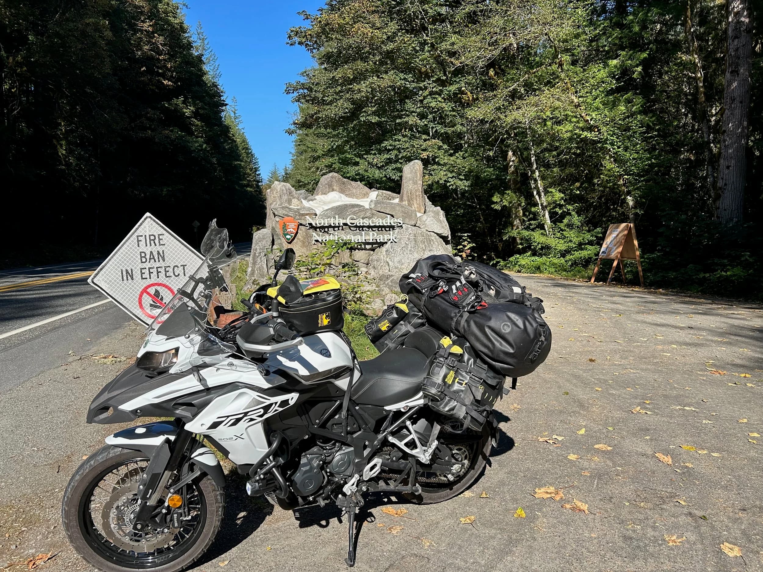 Trip Report: NW National Parks Loop
I left my job recently to take a much needed sabbatical and figure out what I’m doing next. A few weeks after my last day at work I embarked on what was to be a three week tour of NW-ish National Parks from Portland, to include Olympic, North Cascades, Glacier, Yellowstone, Grand Teton, Craters of the Moon, Lassen Volcanic, and Crater Lake.
I ended up missing Grand Tetons due to weather and I had to cut the trip short before I got to Lassen (family medical issue), so Lassen and Crater Lake remain unvisited.
Trip Dates: Sept 3 - Sept 16 (13 days)
Total Travel Miles: 3478 (does not include local miles for store runs, etc.)
Total Gallons of Gas Used: 82
Equipment: 2021 Benelli TRK502X Gaia GPS & Google Maps running on Sonim XP8 rugged Android phoneButler Motorcycle Maps (paper maps of best M/C roads in the country) iPhone 14 (main camera) Akaso Brave 7 helmet-mounted adventure camera Spot X satellite communicator and tracker Wolfman Luggage WP waterproof tank bag and saddle bags (no longer available) Watershed Colorado dry bag duffel (across the pillion seat) Kriega US-5 Drypack (tail bag) Kriega 3L hydration backpack (strapped to duffel, not worn)Marmot Ajax 2 tent Nemo hydrophobic down sleeping bag (non-mummy)Helinox ultralight cot MSR WhisperLite International stove
(Purchased in 1991 for my first moto trip: Detroit, MI to San Diego and back on an XT250)Gossamer Gear Bare Boxer bear-proof food canisters (two - one in each saddle bag)
Day 1 - Olympic National Park Date: Tuesday 9/3/2024
Destination: South Beach Campground, Olympic National Park
Travel Time: 4h 24m
Miles: 213Notes:
Planned to head west to Astoria then north from there, but left later than expected so headed up I-5 to US 12. I’ve driven/ridden that stretch of I-5 hundreds of times (starting in 1993). It’s boring and I hate it.
South Beach CG is first-come-first-served. I didn’t have issue getting a site. There is a long, tight loop of sites along the coastline, but I chose one of the sites further back near the bathrooms due to wind concerns. The bathroom building provided a sort of wind shelter for my site.
I used the heated grips on this leg; it was pretty chilly along the coast in the Olympic Peninsula. I almost didn’t install them, thinking I was being paranoid about the cold. I ended up using them a lot.
Day 2 - Ferry to Seattle / Burien Date: Wednesday 9/4/2024
Destination: Friend’s house in Burien, WA
Travel Time: 7h 30m
Miles: 199
Notes:
Slept well (thanks to Advil PM). I’ve not been sleeping well for more than a year. I’m really hoping to reset my sleep patterns with this trip. A good night’s sleep is one of my great joys and I feel like I’ve been robbed of that pleasure.
Used my Aeropress this morning for the first time ever. I’m hooked.
Headed up along US 101 through Port Angeles and then down to the Southworth ferry terminal near Port Orchard. Ferried across to Fauntleroy, which is just a few miles north my friend’s house in Burien. I’m always surprised at how long it takes to get from the Olympic Peninsula to the east side of Puget Sound (Seattle, etc.). With the ferry crossing (I love ferries) it took seven and a half hours to go 200 miles.
Discovered at my first stop of the day (just up 101 at the Kalaloch Campground, stopped to refill water) that the battery is quite weak and won’t start the bike if you leave the ignition on for even two minutes without the motor running. This would become a theme for the next few days. Fortunately, I have a jumper box and a permanent jump harness wired to the battery so jump starts are a quick operation.
Had a good evening with old friends.
Day 3 - North Cascades via Mountain Loop RoadDate: Thursday 9/5/2024
Destination: Newhalem Campground, North Cascades National Park
Travel Time: 4h 30m
Miles: 146Notes:
Slept well, on the couch. No pills needed.
I realized yesterday that my summer riding gloves (Rev’It Dune) were a size (or two) too small. Rev’It gloves fit really tight and I feel like I can never get it quite right. And yet, I love them. So, I stopped at a Cycle Gear in Bellevue to pick up something summer weight (Dirt 3) that fit better. They’re better, but maybe still one size too small. Such is life.
From Bellevue, I rode north and took the Mountain Loop Hwy then on up north to North Cascades. It was a hot ride. Still summer.
A small section of the Mountain Loop Road is dirt/gravel, which I didn’t realize. No biggie. Was just surprised (clearly I didn’t study my maps closely enough). When riding solo on a bike that weighs over 500 lbs., I tend to avoid planning much off-pavement riding. That’s what my DR-Z is for.
Day 4 - Newport, Washington via Winthrop Date: Friday 9/6/2024
Destination: Golden Spur Motor Inn, Newport, Washington
Travel Time: 8h
Miles: 308
Notes:
Slept just ok, even with Advil PM.
Pretty ride through North Cascades National Park and Colville National Forest. Didn’t do any backroads or hikes. Discovered (new to me) the town of Winthrop. Stopped for coffee at Sheri’s and resupplied on freeze-dried food at Cascades Outdoor Store.
The town of Newport is almost nothing, but, inexplicably, there’s an amazing restaurant (Brownell’s Place). Had dinner and a few ciders. Met and chatted with the owner/chef (she’s great). Listened to some live music. Then back to the motel.
Day 5 - New Battery in Kalispell Date: Saturday 9/7/2024
Destination: West Glacier KOA, West Glacier, MT
Travel Time: 8h 7m
Miles: 293
Notes:
Slept well on motel bed (on sleeping bag, not in the sheets). Another hot one.
Discovered that the water pump seal leaks oil. A quick post in the TRK Facebook group revealed that this is a common problem on this bike, and and easy fix. It’s apparently just a bad o-ring.
Battery has been getting continuously worse, and now requires I jump start the bike about every other start. Google Maps to the rescue: directions to the Batteries Plus in Kalispell, please. They don’t have an Odyssey AGM in the right size; the Duracell will have to do. (It’s been great.)
I set up camp at the West Glacier KOA, which will be my base for a few days. KOAs are their own little world. Very strange. Not really my thing, but the on-site laundry was handy.
After setting up camp I opened a cider and used the iPad to book a vehicle reservation for the next day to ride Going to the Sun Road, which I really wanted to do.
Day 6 - Going to the Sun RoadDate: Sunday 9/8/2024
Destination: Local Ride: West Glacier, Going to the Sun Road, Saint Mary, East Glacier
Travel Time: 5h 35m
Miles: 142Notes:
Quick breakfast and gas up in West Glacier before entering Going to the Sun Road.
Going to the Sun Road was stunning. This was the first point in the trip where I had tingles and was giddy at what I was seeing.
Took a very short hike along Saint Mary Lake. Again, I was beside myself with the beauty.
Lunch at the general store in Kiowa.
The rest of the ride back after East Glacier was meh, but I just kept thinking about how amazing what I’d seen in the morning had been.
Dinner at the KOA. Tacos from a cart (ok / not great, and a very weird guacamole) and a few glasses of wine from another cart. I asked about the guac and it turns out they make it in a food processor. Come on, people.
Day 7 - Ride to BozemanDate: Monday 9/9/2024
Destination: Friend’s house in Bozeman, Montana
Travel Time: ~ 8h (Gaia crashed near the end of the trip, but before getting to Bozeman)
Miles: ~ 400Notes:
Slept poorly again. No pills this time. Took some photos of my soft luggage setup to answer some questions in the TRK502X Facebook group. The saddle bags are from Wolfman Luggage, but I don’t think they make this waterproof line anymore. I use a duffel dry bag from Watershed across the top. A heat shield protects the side bag from exhaust heat.
Hazy, smoky ride most of the way. Very windy in places. This is where I first really started to feel how underpowered the TRK502 is. Really struggled in places.
Developed an engine-speed-sensitive squeak or rattle. Sounds like when a heat shield vibrates in resonance with engine vibration. Discovered that it’s a missing crash bar mounting bolt allowing the crash bar to rub against the frame.
Also noticed that there’s a resonant oscillation at speed that feels like the chain going bad (like it’s stretching unevenly).
First of several nights at a friend’s house in Bozeman (which, it turns out, is a pretty cool town). And there’s a hot tub…
Day 8 - Bike Maintenance & Hyalite ReservoirDate: Tuesday 9/10/2024
Destination: Local Ride: Hyalite Reservoir
Travel Time: not recorded
Miles: not recordedNotes:
Woke up to a smoky sunrise. I had the best night’s sleep I’ve had in years. This is was the whole point of this trip: to untangle my burnout and reclaim sleep as one of my joys. I wrote about it in my journal when I woke up. I hope this wasn’t a fluke.
Planned to replace the bolt that rattled loose from the crash bar, but instead discovered that it had actually severed off at the mount point. No fixing that on the road. Adjusted chain and moved on.
Lunch at Mountains Walking Brewery in Bozeman.
Rode up to Hyalite Reservoir. Pretty ride. Smoky still.
Soaked in hot tub after dinner.
Day 9 - North Yellowstone LoopDate: Wednesday 9/11/2024
Destination: Northern loop through Yellowstone National Park
Travel Time: 9h 36m
Miles: 272Notes:
Did a day trip from Bozeman down through the northern loop in Yellowstone, entering at Mammoth and taking the scenic route through Paradise Valley.
Saw elk, coyotes (I think), buffalo, and pronghorn.
Pretty ride, but cold in places. Used heated grips again.
Rode the loop through Mammoth Hot Springs (see video) at the end.
Coffee at Tumbleweed Bookstore & Cafe in Gardiner. I kind of dig Gardiner. Good vibe.
Had dinner at Mountains Walking Brewing. Rain and wind started. Lights flickered. Waited for rain to stop before riding back to the house.
Power out at the house due to high winds. This does not bode well for tomorrow.
Day 10 - Winter Weather in the ParksDate: Thursday 9/12/2024
Destination: Grand Teton National Park via West Yellowstone Pocatello, Idaho
Travel Time: 5h 40m
Miles: 201Notes:
Today was supposed to be a gorgeous ride through Yellowstone into Grand Teton National Park, and camping at Signal Mountain CG in the park. The weather had other ideas. It was pouring rain (and cold) all the way to West Yellowstone from Bozeman. By the time I got to West Yellowstone I was getting severe winter weather warnings on my phone calling for up to 3 (three!!) inches of snow accumulating in the high passes in the park. It’s bad enough in a car, but that’s a disaster waiting to happen on a motorcycle.
I parked my butt at Mountain Mama’s Cafe in West Yellowstone to warm up / dry off and decide what to do. I almost had myself convinced to push through when I realized that, even if I made it to the campground ok, I’d be setting up camp in the rain and I’d likely be miserable all night. Grand Teton would have to wait.
From West Yellowstone it’s easy to bail west into Idaho and get away from the park weather and elevations. So that’s what I did. It was not a pleasant ride, though. I was in torrential downpours all the way to Idaho Falls.
Arriving in Idaho Falls, I was exhausted and sure I could just find a room for the night. I dropped the bike at a roundabout (short-legged it coming to a stop; I knew it was going so I just rolled away). Guy behind me helped me pick it up. Then, there were no rooms because it was move in week for the two universities there (U of I, ISU). This would become a recurring theme.
I rode further to Blackfoot. Still no rooms.
I called ahead to Pocatello and got a room at a Red Lion there. I was never so happy to be off the bike.
No pictures this day. I couldn’t even get the action camera to turn on.
Day 11 - Craters of the Moon and EBR-1Date: Friday 9/13/2024
Destination: Craters of the Moon National Monument
Travel Time: 4h 20m
Miles: 124
Notes:
I wasn’t sure what my destination would be today but my plan was to do a little nuclear tourism, see Craters of the Moon, and then go somewhere from there. My schedule and day-plan was thrown off by missing Grand Teton National Park and spending a night in Pocatello, which was not on the itinerary at all.
Stopped in Atomic City. Not sure why; I was under the impression that Atomic City was the first city lit by nuclear engergy, but it was practically a ghost town. There are a few houses there, but as far as I could tell all of the business were shuttered. Except, maybe, for the race track; that looked like it might still get used.
Arco, it turns out, is the city celebrated as the first in the world to be lit by nuclear energy. Nothing special about the town, but they do a nice job of making City Hall photo-worthy.
Between Atomic City and Arco is EBR-1 (Experimental Breeder Reactor I) which was the world’s first breeder reactor. The EBR-1 exhibit was closed for the season, but in the lot next to it were some really interesting experimental nuclear heat-transfer jet engines that never made it out of the experimental phase (probably a good thing).
Craters of the Moon is pretty small. If you don’t do any of the walks, it’s literally just a 30 minute road loop. Still, it was an unexpected surprise and delight. I had no idea what to expect but I was positively chuffed at the experience. I noticed that the campground had open sites so I inquired at the entry booth. As luck would have it, the whole campground is first come / first serve. I decided to set up for the night. It’s good to be done early and have some time to read and not stress about making distance.
Day 12 - New Chain in Twin FallsDate: Saturday 9/14/2024
Destination: Battle Mountain, Nevada
Travel Time: 8h 52m
Miles: 335
Notes:
Beautiful morning in Craters of the Moon. While I was breaking camp a parade of classic cars came into the park to drive the loop. I got a picture of one Pontiac down the road in Carey at a gas station.
Carey ended up being an unplanned fork in the road for me. I discovered this morning that my chain was indeed stretching unevenly, and the oscillation I was feeling and hearing was the chain hum changing from a “loose” hum to a “tight” hum rapidly as the tight spot moved around the sprockets. I was supposed to continue west to Mountain Home and then south from there into Nevada. A very scenic route, according to my Butler map. But, between camp and the gas station I got pretty paranoid about the chain snapping at high speed, which, worst case, could lead to a fatal crash.
So I called ahead to a few motorcycle dealers in Mountain Home (on my planned route) to see if they could take me in and replace the chain. No dice. This is the downside of having an obscure motorcycle from an obscure marque - no one wants to work on it. Making matters worse this is an Italian-designed bike built in China, a fact which causes many people to lose the ability to think clearly. “It’s Chinese junk!” Not so. Next.
With Mountain Home out, I tried Twin Falls. My first call was to Adventure Motorsports, and the service manager there took me in with no hesitation. “How soon can you be here?” I didn’t get his name, but my hat’s off to him and his one tech working furiously on a Saturday to beat the 3pm closing time. He said during high season, they get about 15-20 out of town travelers per week who need something done, and they take them all in. I love to hear stuff like this. This shop is in it for the community. They have a nice showroom, too.
With a quality new chain installed, I got a burrito and a MexiCoke at a Mexican place and went on my way. I made it to Battle Mountain, NV, where I decide to get a room. Tomorrow I rejoin my planned scenic route. Day 13 - Desert Mountains in NV, CADate: Sunday 9/15/2024
Destination: Grizzly Campground, Lake Davis (near Portola, CA)
Travel Time: 7h
Miles: 307
Notes:
I love the northern Nevada landscape, and today’s ride didn’t disappoint. US Highway 50 is apparently known as “The Loneliest Highway” but everyone knows about it, so it’s not very lonely. However, after leaving Austin, NV headed west you can take Nevada Highway 722, which dips to the south and follows the old US 50 route. It was completely empty and the twisties through the passes were fun. Highly recommended.
Stopped in Fallon for gas and to find a Micro SD card for the action camera. Walmart to the rescue.
After Reno, I crossed into California and, I swear, it looks different. Norther California desert mountains are so beautiful.
Camped at a nearly empty campground on Lake Davis (very end of the season). The host warned me rain was coming tomorrow.
Day 14 - Unplanned Return HomeDate: Monday 9/16/2024
Destination: Summit Lake Campground, Lassen Volcanic National Park Portland, Oregon (Home)
Travel Time: 10h 32m
Miles: 538Notes:
Last week, my mom went into the hospital for a fairly routine procedure. My brother went to Michigan to help out, as needed, and he went back home to Arizona after she returned home and everything seemed settled.
This morning, while having coffee, I got a call that she’d gone back into the hospital with something that may or may not have been related to the procedure. It seemed like maybe things were ok, but maybe not.
I decided the best thing to do was head home so that I was near an airport if I needed to fly out to Michigan to help out.
I packed up camp and headed up US 395 toward home, via Klamath Falls. It was a pretty ride, but, once again, I found myself in rain most of the way to Klamath Falls.
I was pretty beat by the time I got to Klamath Falls and figured I’d just find a hotel room, get a hot shower, and finish the ride tomorrow.
But, once again, it was move-in week for the local university. Holiday Inn Express had a single room for $395. No thanks. Onward.
I never hit rain again after Klamath Falls, and after turning west onto Oregon Hwy 58 and starting to lose elevation into the Willamette Valley, the temperature starting rising, which was welcome.
Once I reached Eugene, there was no point in not just going all the way home, so that’s what I did.
I got two pictures: one at camp before the call, and one at my last gas stop, an hour and twenty minutes from home, with the moon rising.
A nice side effect of my early return home is that I was home for my birthday (tomorrow), so I had dinner with my kids and my wife, which was lovely.
I did end up flying to Michigan the next day, and was there for a bit. The best part? I got to make some meals for my mom and step dad. Everything seems ok with my mom for now.
Grand Teton, Lassen, and Crater Lake will be there, and now I have an excuse for another trip in the future.