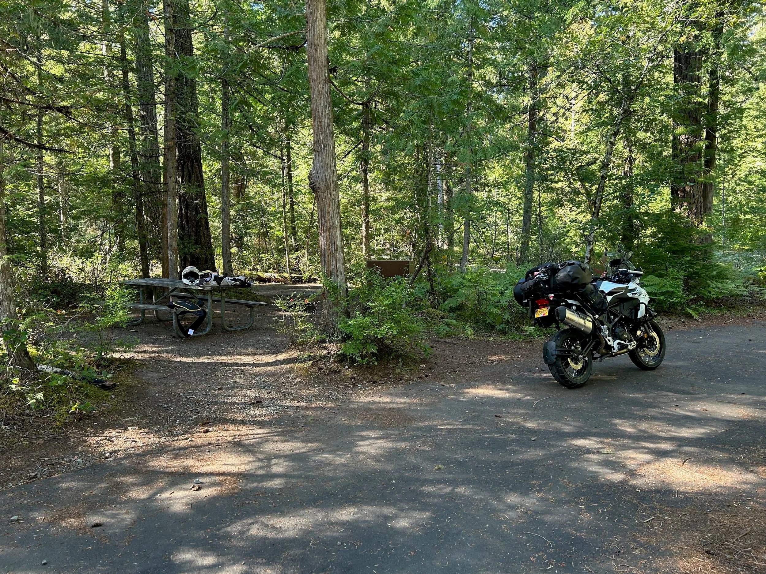 Trip Report: NW National Parks Loop
I left my job recently to take a much needed sabbatical and figure out what I’m doing next. A few weeks after my last day at work I embarked on what was to be a three week tour of NW-ish National Parks from Portland, to include Olympic, North Cascades, Glacier, Yellowstone, Grand Teton, Craters of the Moon, Lassen Volcanic, and Crater Lake.
I ended up missing Grand Tetons due to weather and I had to cut the trip short before I got to Lassen (family medical issue), so Lassen and Crater Lake remain unvisited.
Trip Dates: Sept 3 - Sept 16 (13 days)
Total Travel Miles: 3478 (does not include local miles for store runs, etc.)
Total Gallons of Gas Used: 82
Equipment: 2021 Benelli TRK502X Gaia GPS & Google Maps running on Sonim XP8 rugged Android phoneButler Motorcycle Maps (paper maps of best M/C roads in the country) iPhone 14 (main camera) Akaso Brave 7 helmet-mounted adventure camera Spot X satellite communicator and tracker Wolfman Luggage WP waterproof tank bag and saddle bags (no longer available) Watershed Colorado dry bag duffel (across the pillion seat) Kriega US-5 Drypack (tail bag) Kriega 3L hydration backpack (strapped to duffel, not worn)Marmot Ajax 2 tent Nemo hydrophobic down sleeping bag (non-mummy)Helinox ultralight cot MSR WhisperLite International stove
(Purchased in 1991 for my first moto trip: Detroit, MI to San Diego and back on an XT250)Gossamer Gear Bare Boxer bear-proof food canisters (two - one in each saddle bag)
Day 1 - Olympic National Park Date: Tuesday 9/3/2024
Destination: South Beach Campground, Olympic National Park
Travel Time: 4h 24m
Miles: 213Notes:
Planned to head west to Astoria then north from there, but left later than expected so headed up I-5 to US 12. I’ve driven/ridden that stretch of I-5 hundreds of times (starting in 1993). It’s boring and I hate it.
South Beach CG is first-come-first-served. I didn’t have issue getting a site. There is a long, tight loop of sites along the coastline, but I chose one of the sites further back near the bathrooms due to wind concerns. The bathroom building provided a sort of wind shelter for my site.
I used the heated grips on this leg; it was pretty chilly along the coast in the Olympic Peninsula. I almost didn’t install them, thinking I was being paranoid about the cold. I ended up using them a lot.
Day 2 - Ferry to Seattle / Burien Date: Wednesday 9/4/2024
Destination: Friend’s house in Burien, WA
Travel Time: 7h 30m
Miles: 199
Notes:
Slept well (thanks to Advil PM). I’ve not been sleeping well for more than a year. I’m really hoping to reset my sleep patterns with this trip. A good night’s sleep is one of my great joys and I feel like I’ve been robbed of that pleasure.
Used my Aeropress this morning for the first time ever. I’m hooked.
Headed up along US 101 through Port Angeles and then down to the Southworth ferry terminal near Port Orchard. Ferried across to Fauntleroy, which is just a few miles north my friend’s house in Burien. I’m always surprised at how long it takes to get from the Olympic Peninsula to the east side of Puget Sound (Seattle, etc.). With the ferry crossing (I love ferries) it took seven and a half hours to go 200 miles.
Discovered at my first stop of the day (just up 101 at the Kalaloch Campground, stopped to refill water) that the battery is quite weak and won’t start the bike if you leave the ignition on for even two minutes without the motor running. This would become a theme for the next few days. Fortunately, I have a jumper box and a permanent jump harness wired to the battery so jump starts are a quick operation.
Had a good evening with old friends.
Day 3 - North Cascades via Mountain Loop RoadDate: Thursday 9/5/2024
Destination: Newhalem Campground, North Cascades National Park
Travel Time: 4h 30m
Miles: 146Notes:
Slept well, on the couch. No pills needed.
I realized yesterday that my summer riding gloves (Rev’It Dune) were a size (or two) too small. Rev’It gloves fit really tight and I feel like I can never get it quite right. And yet, I love them. So, I stopped at a Cycle Gear in Bellevue to pick up something summer weight (Dirt 3) that fit better. They’re better, but maybe still one size too small. Such is life.
From Bellevue, I rode north and took the Mountain Loop Hwy then on up north to North Cascades. It was a hot ride. Still summer.
A small section of the Mountain Loop Road is dirt/gravel, which I didn’t realize. No biggie. Was just surprised (clearly I didn’t study my maps closely enough). When riding solo on a bike that weighs over 500 lbs., I tend to avoid planning much off-pavement riding. That’s what my DR-Z is for.
Day 4 - Newport, Washington via Winthrop Date: Friday 9/6/2024
Destination: Golden Spur Motor Inn, Newport, Washington
Travel Time: 8h
Miles: 308
Notes:
Slept just ok, even with Advil PM.
Pretty ride through North Cascades National Park and Colville National Forest. Didn’t do any backroads or hikes. Discovered (new to me) the town of Winthrop. Stopped for coffee at Sheri’s and resupplied on freeze-dried food at Cascades Outdoor Store.
The town of Newport is almost nothing, but, inexplicably, there’s an amazing restaurant (Brownell’s Place). Had dinner and a few ciders. Met and chatted with the owner/chef (she’s great). Listened to some live music. Then back to the motel.
Day 5 - New Battery in Kalispell Date: Saturday 9/7/2024
Destination: West Glacier KOA, West Glacier, MT
Travel Time: 8h 7m
Miles: 293
Notes:
Slept well on motel bed (on sleeping bag, not in the sheets). Another hot one.
Discovered that the water pump seal leaks oil. A quick post in the TRK Facebook group revealed that this is a common problem on this bike, and and easy fix. It’s apparently just a bad o-ring.
Battery has been getting continuously worse, and now requires I jump start the bike about every other start. Google Maps to the rescue: directions to the Batteries Plus in Kalispell, please. They don’t have an Odyssey AGM in the right size; the Duracell will have to do. (It’s been great.)
I set up camp at the West Glacier KOA, which will be my base for a few days. KOAs are their own little world. Very strange. Not really my thing, but the on-site laundry was handy.
After setting up camp I opened a cider and used the iPad to book a vehicle reservation for the next day to ride Going to the Sun Road, which I really wanted to do.
Day 6 - Going to the Sun RoadDate: Sunday 9/8/2024
Destination: Local Ride: West Glacier, Going to the Sun Road, Saint Mary, East Glacier
Travel Time: 5h 35m
Miles: 142Notes:
Quick breakfast and gas up in West Glacier before entering Going to the Sun Road.
Going to the Sun Road was stunning. This was the first point in the trip where I had tingles and was giddy at what I was seeing.
Took a very short hike along Saint Mary Lake. Again, I was beside myself with the beauty.
Lunch at the general store in Kiowa.
The rest of the ride back after East Glacier was meh, but I just kept thinking about how amazing what I’d seen in the morning had been.
Dinner at the KOA. Tacos from a cart (ok / not great, and a very weird guacamole) and a few glasses of wine from another cart. I asked about the guac and it turns out they make it in a food processor. Come on, people.
Day 7 - Ride to BozemanDate: Monday 9/9/2024
Destination: Friend’s house in Bozeman, Montana
Travel Time: ~ 8h (Gaia crashed near the end of the trip, but before getting to Bozeman)
Miles: ~ 400Notes:
Slept poorly again. No pills this time. Took some photos of my soft luggage setup to answer some questions in the TRK502X Facebook group. The saddle bags are from Wolfman Luggage, but I don’t think they make this waterproof line anymore. I use a duffel dry bag from Watershed across the top. A heat shield protects the side bag from exhaust heat.
Hazy, smoky ride most of the way. Very windy in places. This is where I first really started to feel how underpowered the TRK502 is. Really struggled in places.
Developed an engine-speed-sensitive squeak or rattle. Sounds like when a heat shield vibrates in resonance with engine vibration. Discovered that it’s a missing crash bar mounting bolt allowing the crash bar to rub against the frame.
Also noticed that there’s a resonant oscillation at speed that feels like the chain going bad (like it’s stretching unevenly).
First of several nights at a friend’s house in Bozeman (which, it turns out, is a pretty cool town). And there’s a hot tub…
Day 8 - Bike Maintenance & Hyalite ReservoirDate: Tuesday 9/10/2024
Destination: Local Ride: Hyalite Reservoir
Travel Time: not recorded
Miles: not recordedNotes:
Woke up to a smoky sunrise. I had the best night’s sleep I’ve had in years. This is was the whole point of this trip: to untangle my burnout and reclaim sleep as one of my joys. I wrote about it in my journal when I woke up. I hope this wasn’t a fluke.
Planned to replace the bolt that rattled loose from the crash bar, but instead discovered that it had actually severed off at the mount point. No fixing that on the road. Adjusted chain and moved on.
Lunch at Mountains Walking Brewery in Bozeman.
Rode up to Hyalite Reservoir. Pretty ride. Smoky still.
Soaked in hot tub after dinner.
Day 9 - North Yellowstone LoopDate: Wednesday 9/11/2024
Destination: Northern loop through Yellowstone National Park
Travel Time: 9h 36m
Miles: 272Notes:
Did a day trip from Bozeman down through the northern loop in Yellowstone, entering at Mammoth and taking the scenic route through Paradise Valley.
Saw elk, coyotes (I think), buffalo, and pronghorn.
Pretty ride, but cold in places. Used heated grips again.
Rode the loop through Mammoth Hot Springs (see video) at the end.
Coffee at Tumbleweed Bookstore & Cafe in Gardiner. I kind of dig Gardiner. Good vibe.
Had dinner at Mountains Walking Brewing. Rain and wind started. Lights flickered. Waited for rain to stop before riding back to the house.
Power out at the house due to high winds. This does not bode well for tomorrow.
Day 10 - Winter Weather in the ParksDate: Thursday 9/12/2024
Destination: Grand Teton National Park via West Yellowstone Pocatello, Idaho
Travel Time: 5h 40m
Miles: 201Notes:
Today was supposed to be a gorgeous ride through Yellowstone into Grand Teton National Park, and camping at Signal Mountain CG in the park. The weather had other ideas. It was pouring rain (and cold) all the way to West Yellowstone from Bozeman. By the time I got to West Yellowstone I was getting severe winter weather warnings on my phone calling for up to 3 (three!!) inches of snow accumulating in the high passes in the park. It’s bad enough in a car, but that’s a disaster waiting to happen on a motorcycle.
I parked my butt at Mountain Mama’s Cafe in West Yellowstone to warm up / dry off and decide what to do. I almost had myself convinced to push through when I realized that, even if I made it to the campground ok, I’d be setting up camp in the rain and I’d likely be miserable all night. Grand Teton would have to wait.
From West Yellowstone it’s easy to bail west into Idaho and get away from the park weather and elevations. So that’s what I did. It was not a pleasant ride, though. I was in torrential downpours all the way to Idaho Falls.
Arriving in Idaho Falls, I was exhausted and sure I could just find a room for the night. I dropped the bike at a roundabout (short-legged it coming to a stop; I knew it was going so I just rolled away). Guy behind me helped me pick it up. Then, there were no rooms because it was move in week for the two universities there (U of I, ISU). This would become a recurring theme.
I rode further to Blackfoot. Still no rooms.
I called ahead to Pocatello and got a room at a Red Lion there. I was never so happy to be off the bike.
No pictures this day. I couldn’t even get the action camera to turn on.
Day 11 - Craters of the Moon and EBR-1Date: Friday 9/13/2024
Destination: Craters of the Moon National Monument
Travel Time: 4h 20m
Miles: 124
Notes:
I wasn’t sure what my destination would be today but my plan was to do a little nuclear tourism, see Craters of the Moon, and then go somewhere from there. My schedule and day-plan was thrown off by missing Grand Teton National Park and spending a night in Pocatello, which was not on the itinerary at all.
Stopped in Atomic City. Not sure why; I was under the impression that Atomic City was the first city lit by nuclear engergy, but it was practically a ghost town. There are a few houses there, but as far as I could tell all of the business were shuttered. Except, maybe, for the race track; that looked like it might still get used.
Arco, it turns out, is the city celebrated as the first in the world to be lit by nuclear energy. Nothing special about the town, but they do a nice job of making City Hall photo-worthy.
Between Atomic City and Arco is EBR-1 (Experimental Breeder Reactor I) which was the world’s first breeder reactor. The EBR-1 exhibit was closed for the season, but in the lot next to it were some really interesting experimental nuclear heat-transfer jet engines that never made it out of the experimental phase (probably a good thing).
Craters of the Moon is pretty small. If you don’t do any of the walks, it’s literally just a 30 minute road loop. Still, it was an unexpected surprise and delight. I had no idea what to expect but I was positively chuffed at the experience. I noticed that the campground had open sites so I inquired at the entry booth. As luck would have it, the whole campground is first come / first serve. I decided to set up for the night. It’s good to be done early and have some time to read and not stress about making distance.
Day 12 - New Chain in Twin FallsDate: Saturday 9/14/2024
Destination: Battle Mountain, Nevada
Travel Time: 8h 52m
Miles: 335
Notes:
Beautiful morning in Craters of the Moon. While I was breaking camp a parade of classic cars came into the park to drive the loop. I got a picture of one Pontiac down the road in Carey at a gas station.
Carey ended up being an unplanned fork in the road for me. I discovered this morning that my chain was indeed stretching unevenly, and the oscillation I was feeling and hearing was the chain hum changing from a “loose” hum to a “tight” hum rapidly as the tight spot moved around the sprockets. I was supposed to continue west to Mountain Home and then south from there into Nevada. A very scenic route, according to my Butler map. But, between camp and the gas station I got pretty paranoid about the chain snapping at high speed, which, worst case, could lead to a fatal crash.
So I called ahead to a few motorcycle dealers in Mountain Home (on my planned route) to see if they could take me in and replace the chain. No dice. This is the downside of having an obscure motorcycle from an obscure marque - no one wants to work on it. Making matters worse this is an Italian-designed bike built in China, a fact which causes many people to lose the ability to think clearly. “It’s Chinese junk!” Not so. Next.
With Mountain Home out, I tried Twin Falls. My first call was to Adventure Motorsports, and the service manager there took me in with no hesitation. “How soon can you be here?” I didn’t get his name, but my hat’s off to him and his one tech working furiously on a Saturday to beat the 3pm closing time. He said during high season, they get about 15-20 out of town travelers per week who need something done, and they take them all in. I love to hear stuff like this. This shop is in it for the community. They have a nice showroom, too.
With a quality new chain installed, I got a burrito and a MexiCoke at a Mexican place and went on my way. I made it to Battle Mountain, NV, where I decide to get a room. Tomorrow I rejoin my planned scenic route. Day 13 - Desert Mountains in NV, CADate: Sunday 9/15/2024
Destination: Grizzly Campground, Lake Davis (near Portola, CA)
Travel Time: 7h
Miles: 307
Notes:
I love the northern Nevada landscape, and today’s ride didn’t disappoint. US Highway 50 is apparently known as “The Loneliest Highway” but everyone knows about it, so it’s not very lonely. However, after leaving Austin, NV headed west you can take Nevada Highway 722, which dips to the south and follows the old US 50 route. It was completely empty and the twisties through the passes were fun. Highly recommended.
Stopped in Fallon for gas and to find a Micro SD card for the action camera. Walmart to the rescue.
After Reno, I crossed into California and, I swear, it looks different. Norther California desert mountains are so beautiful.
Camped at a nearly empty campground on Lake Davis (very end of the season). The host warned me rain was coming tomorrow.
Day 14 - Unplanned Return HomeDate: Monday 9/16/2024
Destination: Summit Lake Campground, Lassen Volcanic National Park Portland, Oregon (Home)
Travel Time: 10h 32m
Miles: 538Notes:
Last week, my mom went into the hospital for a fairly routine procedure. My brother went to Michigan to help out, as needed, and he went back home to Arizona after she returned home and everything seemed settled.
This morning, while having coffee, I got a call that she’d gone back into the hospital with something that may or may not have been related to the procedure. It seemed like maybe things were ok, but maybe not.
I decided the best thing to do was head home so that I was near an airport if I needed to fly out to Michigan to help out.
I packed up camp and headed up US 395 toward home, via Klamath Falls. It was a pretty ride, but, once again, I found myself in rain most of the way to Klamath Falls.
I was pretty beat by the time I got to Klamath Falls and figured I’d just find a hotel room, get a hot shower, and finish the ride tomorrow.
But, once again, it was move-in week for the local university. Holiday Inn Express had a single room for $395. No thanks. Onward.
I never hit rain again after Klamath Falls, and after turning west onto Oregon Hwy 58 and starting to lose elevation into the Willamette Valley, the temperature starting rising, which was welcome.
Once I reached Eugene, there was no point in not just going all the way home, so that’s what I did.
I got two pictures: one at camp before the call, and one at my last gas stop, an hour and twenty minutes from home, with the moon rising.
A nice side effect of my early return home is that I was home for my birthday (tomorrow), so I had dinner with my kids and my wife, which was lovely.
I did end up flying to Michigan the next day, and was there for a bit. The best part? I got to make some meals for my mom and step dad. Everything seems ok with my mom for now.
Grand Teton, Lassen, and Crater Lake will be there, and now I have an excuse for another trip in the future.