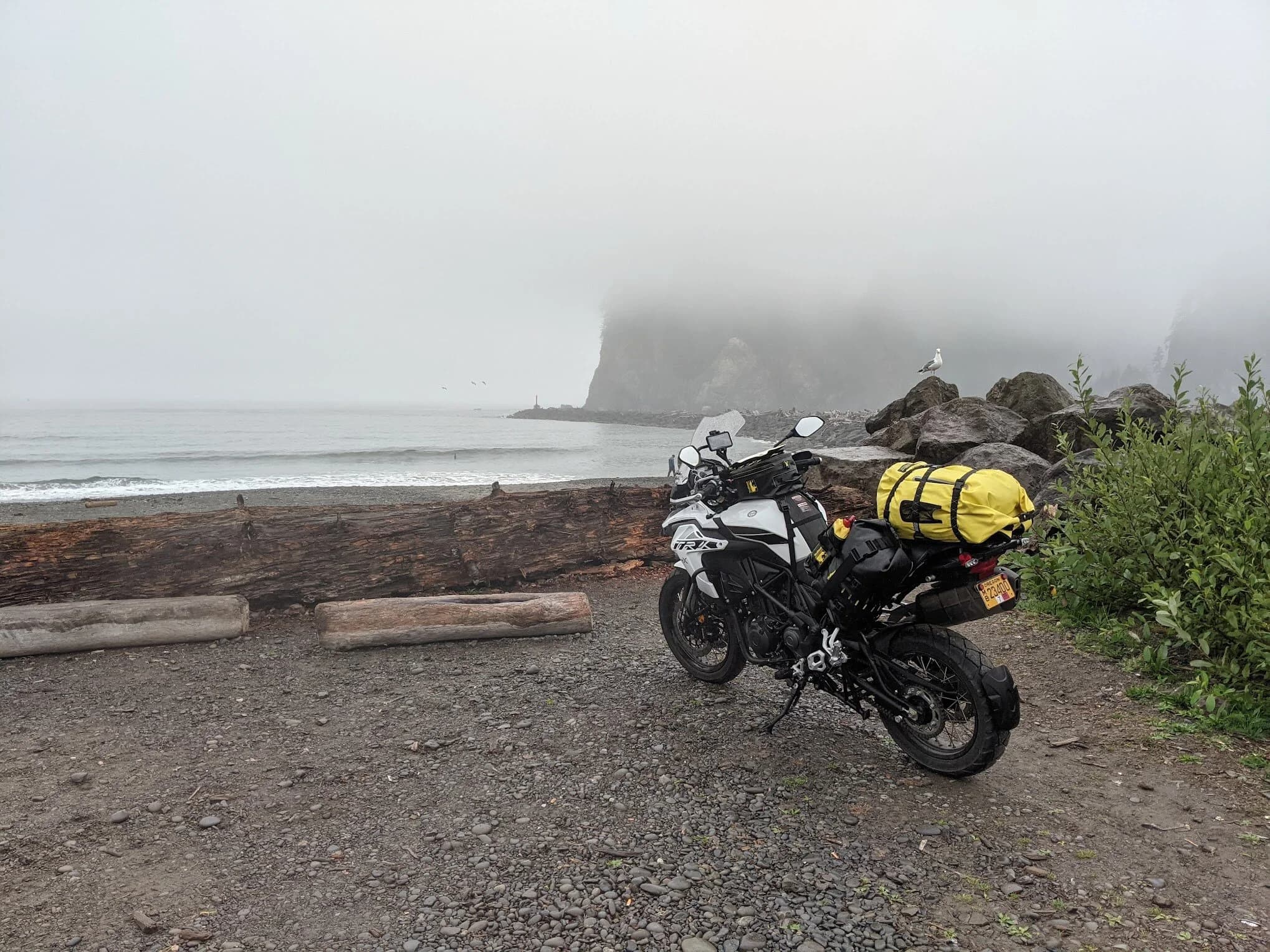 Trip Report: Portland to Olympic Peninsula to Orcas Island
If you follow me on Instagram, you know I purchased a 2021 Benelli TRK502X in July. I just completed my first overnight trip with the new Benelli, doing 7 nights / 8 days from Portland, up the Olympic Peninsula, over to Bellingham and then finally to Orcas Island.
The plan was to camp most or all nights until my last two nights on Orcas, where I had a small waterfront cottage rented right in Orcas Village, where the ferry lands. After three nights of camping, however, I realized I can’t really do the “thin air pad on the ground” thing anymore (I’d be 50 in a week, after all!). My back was killing me and I was not sleeping well, making the following day’s ride less enjoyable at best, and probably also less safe.
So, instead of 5 nights of camping, I did three and then found a cheap motel in Port Angeles, figuring I’d camp the next night and then do my two nights in the cottage. As it happened, most of the next day was rain and the forecast was rain all night and into the morning, so I ended up in a hotel in Bellingham to avoid setting up and breaking down camp in the rain. I can do it. Have done it. But if money is no object and there is lodging available, why be miserable?
The route I planned was intended to get me familiar with the TRK’s manners while allowing for the fact that I’d be riding solo and really didn’t want to get into trouble that I couldn’t get myself out of. The 502X, despite being a 500cc bike, is not light. Curb weight is listed as 518 lbs (dry is 470). So, I favored two lane highways, but included some backcountry single lane roads that were a mix of pavement and gravel.
Here’s my trip report. Day 1Planned / Actual Destination: Cape Disappointment State Park
Planned / Actual Accommodation: Camping
Planned / Actual Miles: 201 / 212
Planned Route: Tigard to Seaside via the Nestucca River Backcountry Byway; Seaside to Cape Disappointment via US 101.
Route NotesI let Google guide me to Carlton from Tigard (home base). On Gaia GPS, I had planned a route that followed the Nestucca River Backcountry Byway from Carlton to Beaver. Unfortunately, there was a detour after McGuire Reservoir (the body of water at the left edge of the right third of the map above) that took me well south down to Bell Mountain along Bald Mountain Rd before heading back north again and rejoining the Nestucca River Rd near Thune Mouintain. Basically, I missed at least half of the scenic route I was hoping for. I wasn’t sure how far the closure went on Nestucca River Rd, and I was still getting the hang of using Gaia to both see where I was, and plan where I wanted to go…so I just followed the signs for the detour. The detour was nice, but it wasn’t the Nestucca River . Most of the route was paved single lane forest road, with a small section of gravel thrown in before the detour.
Once to Beaver, I just rode south on 101 until I saw the signs for Pacific City. Lunch at Pelican Brewery. (I’m not a fan of their new orange grate picnic table outdoor seating.)
After lunch, I rode straight up 101 through Astoria and across to Ilwaco, where I had a reservation to camp at Cape Disappointment. Great spot, right up against the beach (with some trees and brush to break the wind). Camp NotesCape Disappointment was filled mostly with campers pulled by pickup trucks, and my site was nestled between two of them. Most people were friendly. The guy on the north side came over right away to ask about the bike. He’d never seen or heard of Benelli. The guy on the south side came over several times. It’s like he kept looking for excuses to come over and talk more. He even offered me dinner (red beans and rice, with sausage). I accepted. The next morning, he came over with pictures of places I should see in Olympic National Park. The wife of the guy on the north side came over just before I departed for the day’s travels. “Looks like a lot of fun. Nice bike. Reminds me of when we used to backpack. Now we have this thing,” (she gestured to her trailer).
The site itself was great. It was wooded, and sheltered from the beach winds with a thin band of trees and brush, plus a wall of driftwood you had to navigate through and over to get to the beach. The beach itself was gorgeous. Gear NotesI’d read that my trusty MSR Whisperlite Internationale (purchased in 1991) can run on unleaded gasoline just as easily as white gas. Since this kind of moto touring is about going as light and simply as possible, I figured I’d just run unleaded gas instead of bringing white gas. This way, I’d have 1.5 liters of spare gas plus whatever was in my stove bottle in the event that I ran out of gas on the road. Seemed like a great idea.
The reality, as I found out, is that gasoline burns very dirty compared to white gas. It lit, no problem, but the stove was left covered in black soot after a single burn and everything ends up smelling like gasoline. I never realized how much I’d want to smell white gas. So, next trip I’ll ditch the gasoline and go back to white gas.
Also, I threw out my deodorant and body soap before bed. Because I’m using soft bags (not hard aluminum cases) all of my food, toothpaste, and other smelly items need to fit into a small bear canister that fits inside one of my soft bags (keeps rodents out, even if there are no bears). To save space, the stove needs to fit in the bear canister, too. The deodorant and soap simply didn’t fit. So, off they went. Besides, I use Dr. Bronner’s as my dish soap. If I found a shower, I could use that.
Day 2Planned / Actual Destination: South Beach Campground
Planned / Actual Accommodation: Camping
Planned / Actual Miles: 231 / 219
Planned Route: Cape Disappointment up around the Long Beach Peninsula, to South Beach Campground via Raymond, Grayland, Aberdeen, Moclips, Lake Quinault (I skipped the loop around the Long Beach Peninsula)Route NotesToday was a very nice ride. Two lane highway all the way, with a good chunk of it along the coast. I had planned to do a loop up the Long Beach Peninsula, but decided to skip it to save time after spending some time in the morning exploring Cape Disappointment State Park. My destination, South Beach Campground, is first come / first serve and I wasn’t sure how busy it would be, so I didn’t want to arrive too late.
Finding lunch turned out to be a problem. I was avoiding sketchy looking places because the mask wearing seemed to be a problem. I wasn’t looking for conflict. Along the way I discovered the town of Seabrook, which appears to be a vacation shopping mall built specifically to separate you both from reality and your money. Not my kind of place, though I did look to see if there was a place I could eat. Everything looked too fancy for me to roll up in my full moto suit and boots. Where’s a good taco truck when you need one?
I ended up eating in a gas station convenience store (You and I Market) parking lot in Pacific Beach, just up the road from Seabrook with a bunch of day laborers picking up their afternoon tallboys. Gear NotesFor day two, I used Gaia GPS’s route planning feature to set my path to South Beach. It’s quite easy once you figure out the combination of gestures and long-presses (I needed a YouTube video). One caveat is that you either need a data connection (Wi-Fi or mobile data) to be able to do it (if you want the route to snap to a road or trail, which is quite handy), or you need to have downloaded all the map areas and route planning data ahead of time. Ordinarily, this wouldn’t be a problem, but I had brought along two phones: my iPhone (which is my regular phone) for pictures and communication (it would ride in my chest pocket); and Goggle Pixel 3 I’d purchased to use only for navigation (it would be mounted to the handlebars). I don’t have data for the Pixel.
This turned out to be a problem because I hadn’t downloaded all the map areas and route planning data for my trip onto the Pixel (whereas I had downloaded it all to the iPhone). So, I switched to navigating (still with Gaia GPS) on my iPhone and taking pictures with the Pixel for this leg of the trip, hoping I’d get good Wi-Fi at some point which would allow me to download the data I needed onto the Pixel so I could switch back.
This single day of using the iPhone as my navigation device fried the camera. Two days later, Apple published this.
I still really like having two phones on a trip. (I also have a Spot X satellite communicator for off-grid communication.) It’s nice to have one in the pocket that can come out for a quick picture. It’s also nice to have an emergency backup. It would be nice to have a data plan for the nav phone. Short of that, I just need to be better about downloading map areas and routing data ahead of time (and not using my iPhone for nav). Camp NotesSouth Beach Campground is right on the water, and it’s first-come, first-served. The weather was good, and I felt lucky to get a spot. There were several spots available as it turned out. As I was riding around trying to choose which spot to take, there was a couple with a pickup camper waving me in next to them. This was a first. “We ride!” they exclaimed. So that’s where I set up camp.
The guy’s name was Steve Miller. He sells CBD products online. Seems on brand. They were an amazingly friendly couple, actually. Both ride BMW’s and Steve, especially, was really curious and enthusiastic about the TRK. The bike was really turning out to be a conversation starter. He came over several different times while I was setting up camp and making dinner to ask questions or share info about riding groups he’s a part of. It was really quite welcome.
In the morning they gifted me some carrot zucchini bread for breakfast and then broke camp and pulled out well before I did.