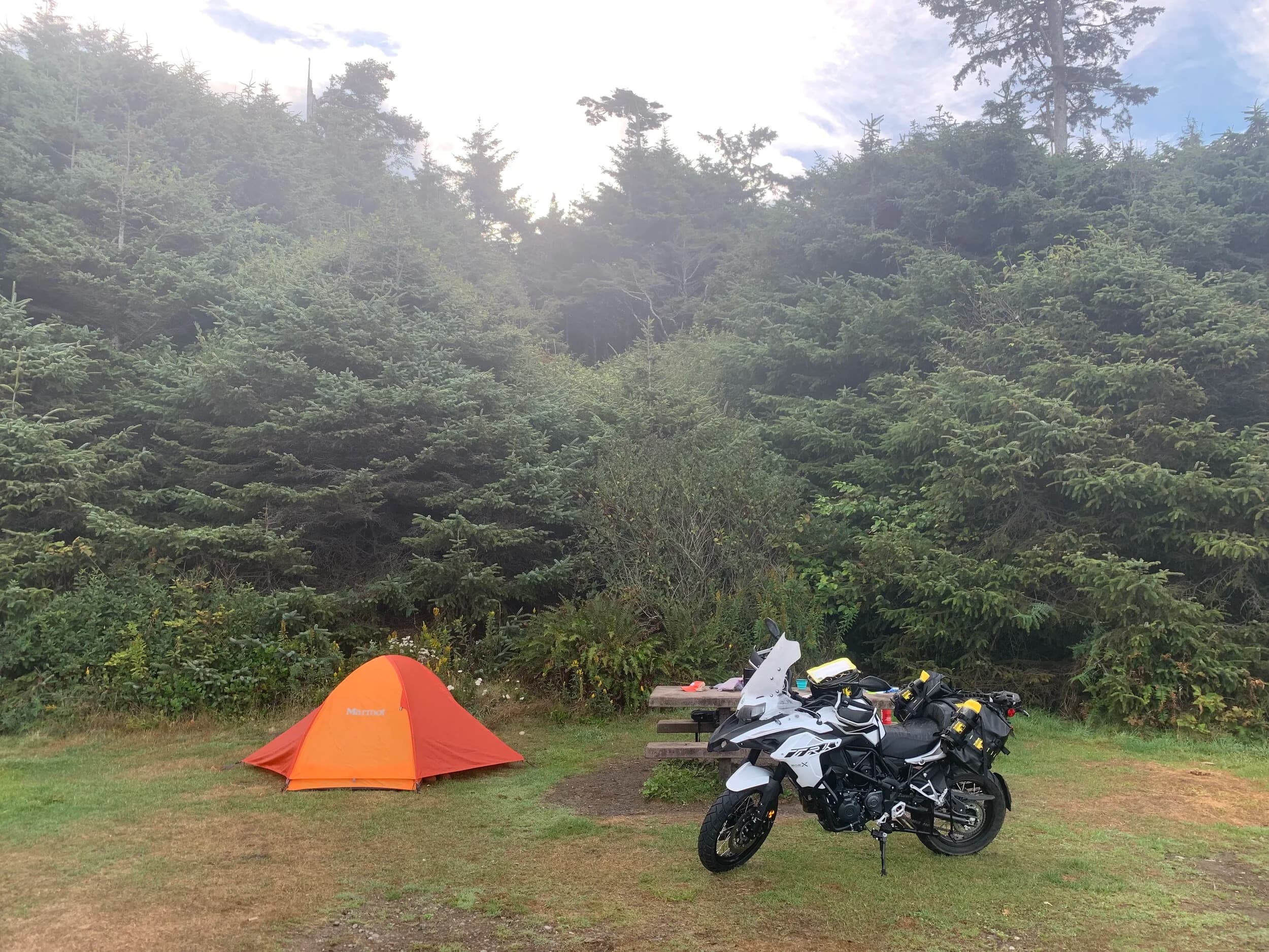 Trip Report: Portland to Olympic Peninsula to Orcas Island
If you follow me on Instagram, you know I purchased a 2021 Benelli TRK502X in July. I just completed my first overnight trip with the new Benelli, doing 7 nights / 8 days from Portland, up the Olympic Peninsula, over to Bellingham and then finally to Orcas Island.
The plan was to camp most or all nights until my last two nights on Orcas, where I had a small waterfront cottage rented right in Orcas Village, where the ferry lands. After three nights of camping, however, I realized I can’t really do the “thin air pad on the ground” thing anymore (I’d be 50 in a week, after all!). My back was killing me and I was not sleeping well, making the following day’s ride less enjoyable at best, and probably also less safe.
So, instead of 5 nights of camping, I did three and then found a cheap motel in Port Angeles, figuring I’d camp the next night and then do my two nights in the cottage. As it happened, most of the next day was rain and the forecast was rain all night and into the morning, so I ended up in a hotel in Bellingham to avoid setting up and breaking down camp in the rain. I can do it. Have done it. But if money is no object and there is lodging available, why be miserable?
The route I planned was intended to get me familiar with the TRK’s manners while allowing for the fact that I’d be riding solo and really didn’t want to get into trouble that I couldn’t get myself out of. The 502X, despite being a 500cc bike, is not light. Curb weight is listed as 518 lbs (dry is 470). So, I favored two lane highways, but included some backcountry single lane roads that were a mix of pavement and gravel.
Here’s my trip report. Day 1Planned / Actual Destination: Cape Disappointment State Park
Planned / Actual Accommodation: Camping
Planned / Actual Miles: 201 / 212
Planned Route: Tigard to Seaside via the Nestucca River Backcountry Byway; Seaside to Cape Disappointment via US 101.
Route NotesI let Google guide me to Carlton from Tigard (home base). On Gaia GPS, I had planned a route that followed the Nestucca River Backcountry Byway from Carlton to Beaver. Unfortunately, there was a detour after McGuire Reservoir (the body of water at the left edge of the right third of the map above) that took me well south down to Bell Mountain along Bald Mountain Rd before heading back north again and rejoining the Nestucca River Rd near Thune Mouintain. Basically, I missed at least half of the scenic route I was hoping for. I wasn’t sure how far the closure went on Nestucca River Rd, and I was still getting the hang of using Gaia to both see where I was, and plan where I wanted to go…so I just followed the signs for the detour. The detour was nice, but it wasn’t the Nestucca River . Most of the route was paved single lane forest road, with a small section of gravel thrown in before the detour.
Once to Beaver, I just rode south on 101 until I saw the signs for Pacific City. Lunch at Pelican Brewery. (I’m not a fan of their new orange grate picnic table outdoor seating.)
After lunch, I rode straight up 101 through Astoria and across to Ilwaco, where I had a reservation to camp at Cape Disappointment. Great spot, right up against the beach (with some trees and brush to break the wind). Camp NotesCape Disappointment was filled mostly with campers pulled by pickup trucks, and my site was nestled between two of them. Most people were friendly. The guy on the north side came over right away to ask about the bike. He’d never seen or heard of Benelli. The guy on the south side came over several times. It’s like he kept looking for excuses to come over and talk more. He even offered me dinner (red beans and rice, with sausage). I accepted. The next morning, he came over with pictures of places I should see in Olympic National Park. The wife of the guy on the north side came over just before I departed for the day’s travels. “Looks like a lot of fun. Nice bike. Reminds me of when we used to backpack. Now we have this thing,” (she gestured to her trailer).
The site itself was great. It was wooded, and sheltered from the beach winds with a thin band of trees and brush, plus a wall of driftwood you had to navigate through and over to get to the beach. The beach itself was gorgeous. Gear NotesI’d read that my trusty MSR Whisperlite Internationale (purchased in 1991) can run on unleaded gasoline just as easily as white gas. Since this kind of moto touring is about going as light and simply as possible, I figured I’d just run unleaded gas instead of bringing white gas. This way, I’d have 1.5 liters of spare gas plus whatever was in my stove bottle in the event that I ran out of gas on the road. Seemed like a great idea.
The reality, as I found out, is that gasoline burns very dirty compared to white gas. It lit, no problem, but the stove was left covered in black soot after a single burn and everything ends up smelling like gasoline. I never realized how much I’d want to smell white gas. So, next trip I’ll ditch the gasoline and go back to white gas.
Also, I threw out my deodorant and body soap before bed. Because I’m using soft bags (not hard aluminum cases) all of my food, toothpaste, and other smelly items need to fit into a small bear canister that fits inside one of my soft bags (keeps rodents out, even if there are no bears). To save space, the stove needs to fit in the bear canister, too. The deodorant and soap simply didn’t fit. So, off they went. Besides, I use Dr. Bronner’s as my dish soap. If I found a shower, I could use that.
Day 2Planned / Actual Destination: South Beach Campground
Planned / Actual Accommodation: Camping
Planned / Actual Miles: 231 / 219
Planned Route: Cape Disappointment up around the Long Beach Peninsula, to South Beach Campground via Raymond, Grayland, Aberdeen, Moclips, Lake Quinault (I skipped the loop around the Long Beach Peninsula)Route NotesToday was a very nice ride. Two lane highway all the way, with a good chunk of it along the coast. I had planned to do a loop up the Long Beach Peninsula, but decided to skip it to save time after spending some time in the morning exploring Cape Disappointment State Park. My destination, South Beach Campground, is first come / first serve and I wasn’t sure how busy it would be, so I didn’t want to arrive too late.
Finding lunch turned out to be a problem. I was avoiding sketchy looking places because the mask wearing seemed to be a problem. I wasn’t looking for conflict. Along the way I discovered the town of Seabrook, which appears to be a vacation shopping mall built specifically to separate you both from reality and your money. Not my kind of place, though I did look to see if there was a place I could eat. Everything looked too fancy for me to roll up in my full moto suit and boots. Where’s a good taco truck when you need one?
I ended up eating in a gas station convenience store (You and I Market) parking lot in Pacific Beach, just up the road from Seabrook with a bunch of day laborers picking up their afternoon tallboys. Gear NotesFor day two, I used Gaia GPS’s route planning feature to set my path to South Beach. It’s quite easy once you figure out the combination of gestures and long-presses (I needed a YouTube video). One caveat is that you either need a data connection (Wi-Fi or mobile data) to be able to do it (if you want the route to snap to a road or trail, which is quite handy), or you need to have downloaded all the map areas and route planning data ahead of time. Ordinarily, this wouldn’t be a problem, but I had brought along two phones: my iPhone (which is my regular phone) for pictures and communication (it would ride in my chest pocket); and Goggle Pixel 3 I’d purchased to use only for navigation (it would be mounted to the handlebars). I don’t have data for the Pixel.
This turned out to be a problem because I hadn’t downloaded all the map areas and route planning data for my trip onto the Pixel (whereas I had downloaded it all to the iPhone). So, I switched to navigating (still with Gaia GPS) on my iPhone and taking pictures with the Pixel for this leg of the trip, hoping I’d get good Wi-Fi at some point which would allow me to download the data I needed onto the Pixel so I could switch back.
This single day of using the iPhone as my navigation device fried the camera. Two days later, Apple published this.
I still really like having two phones on a trip. (I also have a Spot X satellite communicator for off-grid communication.) It’s nice to have one in the pocket that can come out for a quick picture. It’s also nice to have an emergency backup. It would be nice to have a data plan for the nav phone. Short of that, I just need to be better about downloading map areas and routing data ahead of time (and not using my iPhone for nav). Camp NotesSouth Beach Campground is right on the water, and it’s first-come, first-served. The weather was good, and I felt lucky to get a spot. There were several spots available as it turned out. As I was riding around trying to choose which spot to take, there was a couple with a pickup camper waving me in next to them. This was a first. “We ride!” they exclaimed. So that’s where I set up camp.
The guy’s name was Steve Miller. He sells CBD products online. Seems on brand. They were an amazingly friendly couple, actually. Both ride BMW’s and Steve, especially, was really curious and enthusiastic about the TRK. The bike was really turning out to be a conversation starter. He came over several different times while I was setting up camp and making dinner to ask questions or share info about riding groups he’s a part of. It was really quite welcome.
In the morning they gifted me some carrot zucchini bread for breakfast and then broke camp and pulled out well before I did.
