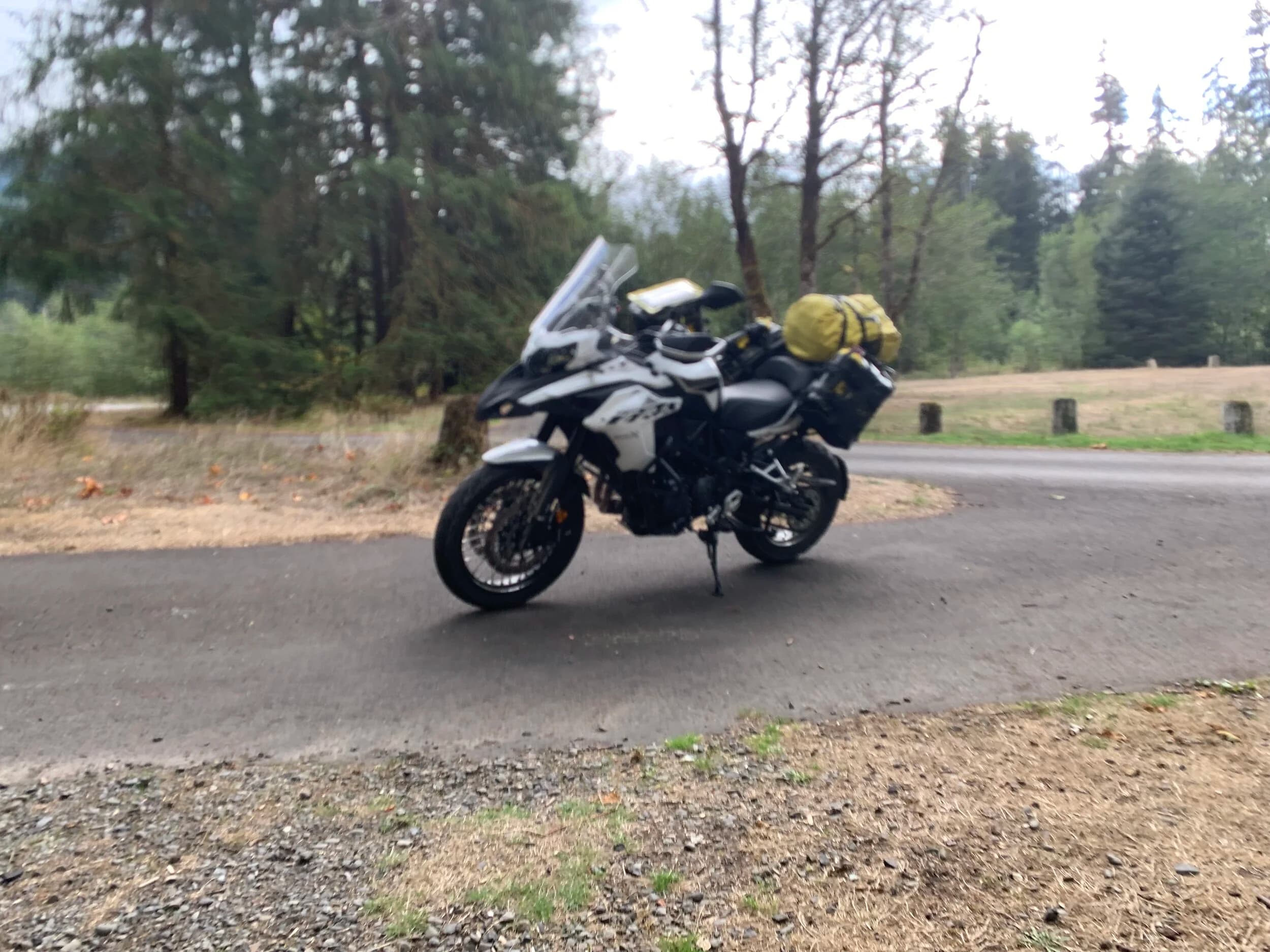 South Beach to Hoh Rainforest
This is the second installment of my trip log of my first overnight trip with the new Benelli TRK502X, doing 7 nights / 8 days from Portland, up the Olympic Peninsula, over to Bellingham and then finally to Orcas Island.
Day 3Planned Destination: Forks or La Push
Actual Destination: Hoh Rainforest Campground
Planned / Actual Accommodation: Camping
Planned / Actual Miles: 100 / 111
Planned Route: Follow the Oly Ride Guide Day Three route published by ADV Pulse, and camp somewhere near Forks or La PushRoute NotesAfter breaking camp I headed south to Queets to get gas and then back up US 101 to the store at Kalaloch to buy a sandwich for lunch for the day and pick up a few beers for the evening. I’d actually had trouble finding a place that was open and that sold beer the night before, so I was going into this day better prepared.
Today’s route was planned to be basically all of the Day 3 section of the ADV Pulse’s Olympic Peninsula route. No specific place planned to camp. I’d just find something when I was done for the day. The day started out well, and I got my first introduction to gravel roads and gravel two track on the TRK. After my experience on the WABDR on the Quota (which I haven’t written about, but I crashed hard; the Quota is in the garage patiently waiting to be rehabbed now), I was taking things slow and easy. The TRK isn’t that much lighter than the Quota, even though it’s half a liter smaller engine-wise, and I’m not sure yet if I can pick it up, so I didn’t want to get too excited and get myself into trouble again. Plus, I’m running the 80/10 Metzler Tourance tires that came on the bike; slow and easy.
I did build some confidence, but I never pushed hard. I thought about this a lot as I was riding actually. I mean, I could have pushed a lot harder. Why wasn’t I? The answer is simple. For me, adventure motorcycling (well, life in general) is about making moments. It’s about stringing together as many great memories as I can while I still can. I’ll remember the great views I “discover” along the way. I’ll remember the interesting people I meet. I’ll remember the trip. But I won’t remember if I pushed hard on any given day or not. I just don’t care about that anymore. Plus, when riding alone, you’re alone if you get into trouble. Better to go easy and get there in one piece.I did run into one issue along the way; the C-2000 road was closed. It appeared that my planned route was closed for the season, which hadn’t been noted in the ride guide. So, I backtracked to the Hoh Mainline Road and rejoined the planned route where Mainline meets Maple Creek Rd. I discovered later, upon closer inspection, that I’d actually missed a turn off of C-2000 (onto a road that isn’t labeled on the map) just before the road closure. Not sure how I rode past that turnoff twice without seeing it. So be it. I have an excuse to go back and do that again. It was all still great riding. Camp NotesIt’s been a while since I camped on the ground on a thin air pad, and it wasn’t really agreeing with me anymore; I hand’t slept well the last two nights. By the time I got to the Hoh Visitor Center I was tired and ready to be done. The Hoh Campground is reservation only, and there were no sites available when I was planning the trip. But, there was a sign at the visitor center beckoning visitors to inquire at the campground desk if there were any camp sites available, so that’s what I did.
I lucked out; there were several sites available. I got a great site with a somewhat secluded tent space (though I worried about tent flooding as it was several feet lower than the surrounding land; fortunately there was no rain). I met a young couple who were actually sleeping in their car. Ouch. They didn’t really know how to camp. She was from Texas but had recently moved to Eugene, Oregon, and he was from England somewhere. She said she was an artist and she’d never done anything like this before. In the morning, she came over and asked if I had a way to heat water so they could have coffee. I obliged.
The guy next to me also came over in the morning and offered me coffee. Motorcycle travel really brings out the friendliness from people in RV trailers. Gear NotesI had noticed a store on the road up to the Hoh visitor center. I rode back to see if they had any food, as I was running low. I hadn’t really been thinking ahead and replenishing food before I needed it, and I was worried that I’d run out. The store had several freeze dried meals, so I picked up something for dinner and some scrambled eggs for breakfast, leaving the food I already had for the next day.
I didn’t have a ton of room for food as I was storing all food (and smelly items) in a small Bare Boxer bear canister from Gossamer Gear. Since I wasn’t running with hard case luggage, I felt I needed a way to keep the rodents (and bears) at bay. The Bare Boxer has room for two days of dinners and breakfasts (freeze dried) plus coffee, some extra oat meal, energy bars, my toothbrush & paste, the dish soap, DEET, and my Whisperlite stove. It worked out quite well the entire trip, actually. Anything that might attract rodents or bears went in the canister, and the canister fit nicely at the bottom of my left-side Wolfman 20L rolie.
As noted above, sleeping on the ground on a thin air pad doesn’t do it for me anymore. My back killed me on the third night, and I did not sleep well at all. I have identified the solution, however. The Helinox Lite Cot. It packs smaller than my air pad and is now on my Christmas wish list. The only downside would be cold weather camping; will need a thin foam pad to provide insulation for temps below freezing, likely.