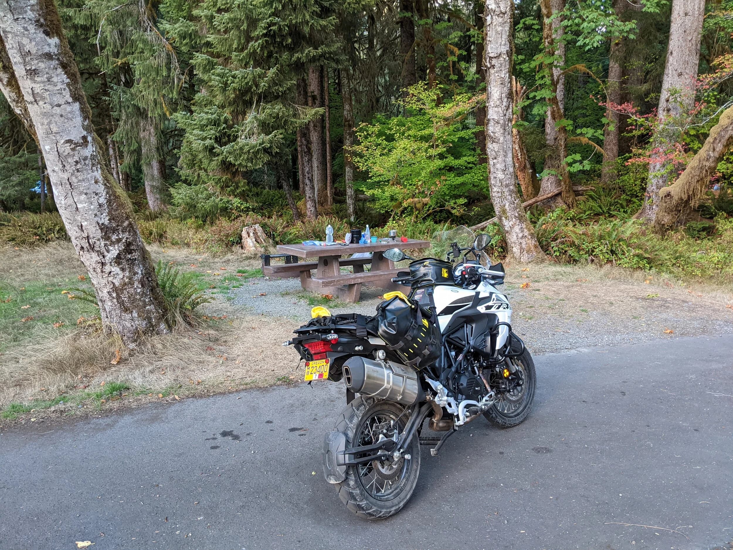 South Beach to Hoh Rainforest
This is the second installment of my trip log of my first overnight trip with the new Benelli TRK502X, doing 7 nights / 8 days from Portland, up the Olympic Peninsula, over to Bellingham and then finally to Orcas Island.
Day 3Planned Destination: Forks or La Push
Actual Destination: Hoh Rainforest Campground
Planned / Actual Accommodation: Camping
Planned / Actual Miles: 100 / 111
Planned Route: Follow the Oly Ride Guide Day Three route published by ADV Pulse, and camp somewhere near Forks or La PushRoute NotesAfter breaking camp I headed south to Queets to get gas and then back up US 101 to the store at Kalaloch to buy a sandwich for lunch for the day and pick up a few beers for the evening. I’d actually had trouble finding a place that was open and that sold beer the night before, so I was going into this day better prepared.
Today’s route was planned to be basically all of the Day 3 section of the ADV Pulse’s Olympic Peninsula route. No specific place planned to camp. I’d just find something when I was done for the day. The day started out well, and I got my first introduction to gravel roads and gravel two track on the TRK. After my experience on the WABDR on the Quota (which I haven’t written about, but I crashed hard; the Quota is in the garage patiently waiting to be rehabbed now), I was taking things slow and easy. The TRK isn’t that much lighter than the Quota, even though it’s half a liter smaller engine-wise, and I’m not sure yet if I can pick it up, so I didn’t want to get too excited and get myself into trouble again. Plus, I’m running the 80/10 Metzler Tourance tires that came on the bike; slow and easy.
I did build some confidence, but I never pushed hard. I thought about this a lot as I was riding actually. I mean, I could have pushed a lot harder. Why wasn’t I? The answer is simple. For me, adventure motorcycling (well, life in general) is about making moments. It’s about stringing together as many great memories as I can while I still can. I’ll remember the great views I “discover” along the way. I’ll remember the interesting people I meet. I’ll remember the trip. But I won’t remember if I pushed hard on any given day or not. I just don’t care about that anymore. Plus, when riding alone, you’re alone if you get into trouble. Better to go easy and get there in one piece.I did run into one issue along the way; the C-2000 road was closed. It appeared that my planned route was closed for the season, which hadn’t been noted in the ride guide. So, I backtracked to the Hoh Mainline Road and rejoined the planned route where Mainline meets Maple Creek Rd. I discovered later, upon closer inspection, that I’d actually missed a turn off of C-2000 (onto a road that isn’t labeled on the map) just before the road closure. Not sure how I rode past that turnoff twice without seeing it. So be it. I have an excuse to go back and do that again. It was all still great riding. Camp NotesIt’s been a while since I camped on the ground on a thin air pad, and it wasn’t really agreeing with me anymore; I hand’t slept well the last two nights. By the time I got to the Hoh Visitor Center I was tired and ready to be done. The Hoh Campground is reservation only, and there were no sites available when I was planning the trip. But, there was a sign at the visitor center beckoning visitors to inquire at the campground desk if there were any camp sites available, so that’s what I did.
I lucked out; there were several sites available. I got a great site with a somewhat secluded tent space (though I worried about tent flooding as it was several feet lower than the surrounding land; fortunately there was no rain). I met a young couple who were actually sleeping in their car. Ouch. They didn’t really know how to camp. She was from Texas but had recently moved to Eugene, Oregon, and he was from England somewhere. She said she was an artist and she’d never done anything like this before. In the morning, she came over and asked if I had a way to heat water so they could have coffee. I obliged.
The guy next to me also came over in the morning and offered me coffee. Motorcycle travel really brings out the friendliness from people in RV trailers. Gear NotesI had noticed a store on the road up to the Hoh visitor center. I rode back to see if they had any food, as I was running low. I hadn’t really been thinking ahead and replenishing food before I needed it, and I was worried that I’d run out. The store had several freeze dried meals, so I picked up something for dinner and some scrambled eggs for breakfast, leaving the food I already had for the next day.
I didn’t have a ton of room for food as I was storing all food (and smelly items) in a small Bare Boxer bear canister from Gossamer Gear. Since I wasn’t running with hard case luggage, I felt I needed a way to keep the rodents (and bears) at bay. The Bare Boxer has room for two days of dinners and breakfasts (freeze dried) plus coffee, some extra oat meal, energy bars, my toothbrush & paste, the dish soap, DEET, and my Whisperlite stove. It worked out quite well the entire trip, actually. Anything that might attract rodents or bears went in the canister, and the canister fit nicely at the bottom of my left-side Wolfman 20L rolie.
As noted above, sleeping on the ground on a thin air pad doesn’t do it for me anymore. My back killed me on the third night, and I did not sleep well at all. I have identified the solution, however. The Helinox Lite Cot. It packs smaller than my air pad and is now on my Christmas wish list. The only downside would be cold weather camping; will need a thin foam pad to provide insulation for temps below freezing, likely.